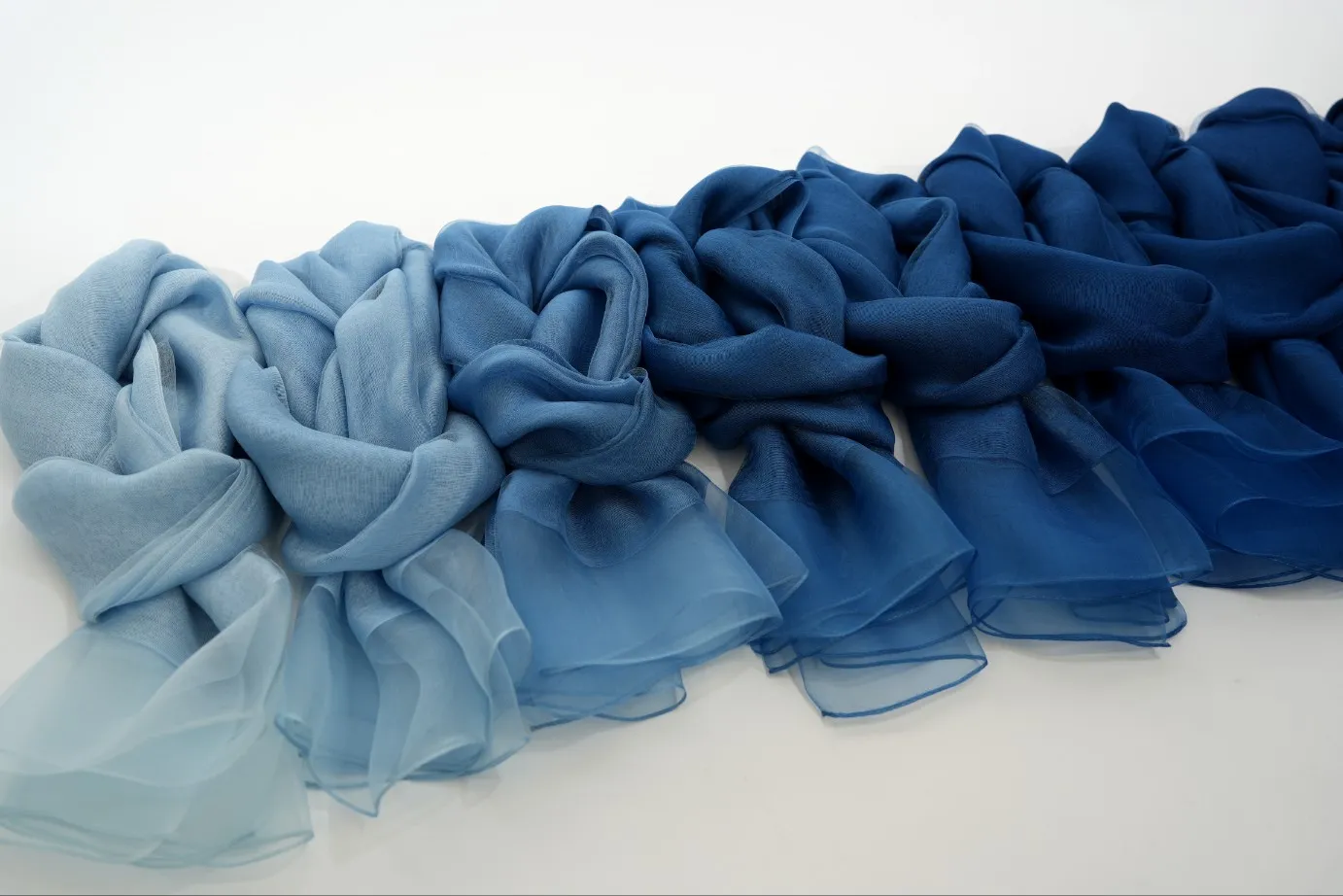 Indigo-dyed scarves arranged in shades of blue.
